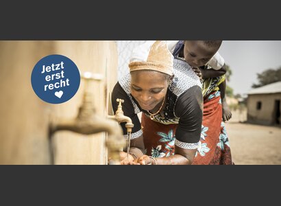 Dado Jacoubou (29) mit Kind am Brunnen im Dorf Toumarou in Benin. | © Simon B. Opladen